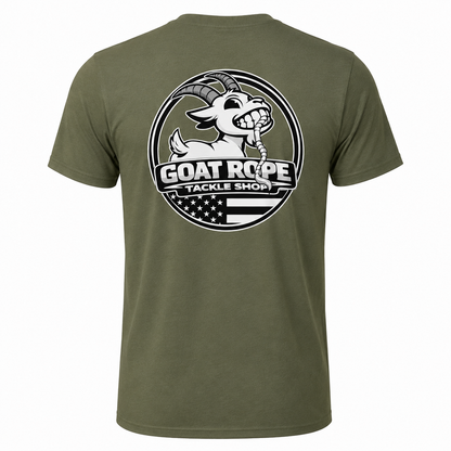An olive green short-sleeve t-shirt shown from the back, featuring a large circular graphic print of a cartoon goat with a fishing line in its mouth and the text 'GOAT ROPE TACKLE SHOP' over a black and white American flag design.