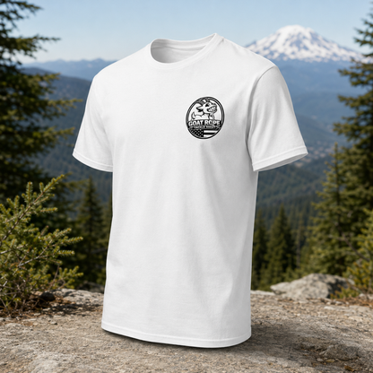 A white short-sleeve crewneck t-shirt with a black circular 'Goat Rest' logo on the left chest, displayed on a rocky mountain peak with pine trees and a snow-capped mountain in the background.