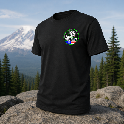 A black short-sleeve t-shirt with a circular 'GOAT REPE' graphic on the left chest, displayed on a large rock with a mountain and pine forest background.