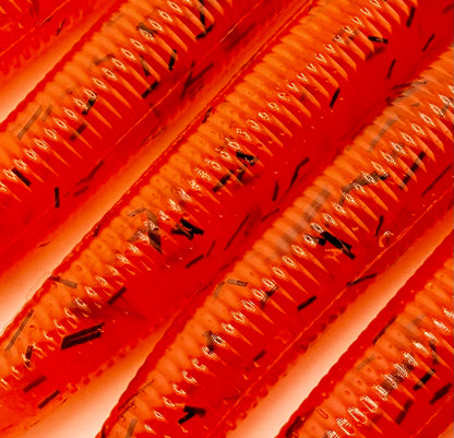 Close-up of orange soft plastic with black whisker glitter on a white background