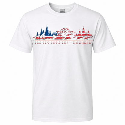 A white short-sleeve crewneck t-shirt featuring a graphic print of a mountain and fishing tackle shop in a stylized American flag pattern, with the text 'GOAT ROPE TACKLE SHOP - PORT Orchard WA' printed below.