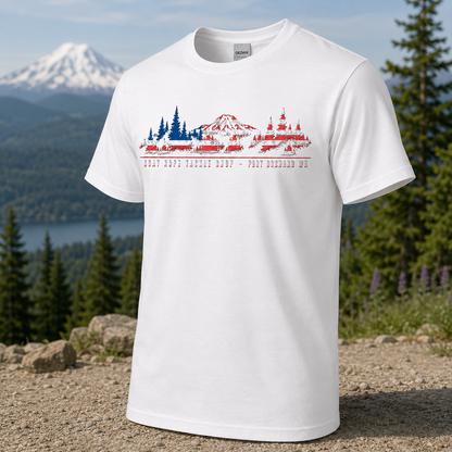 A white short-sleeve crewneck t-shirt with a red and blue graphic print of a mountain landscape with graphic a white short-sleeve crewneck t-shirt featuring a graphic print of a mountain and fishing tackle shop in a stylized American flag pattern, with the text 'GOAT ROPE TACKLE SHOP - PORT Orchard WA' printed below.